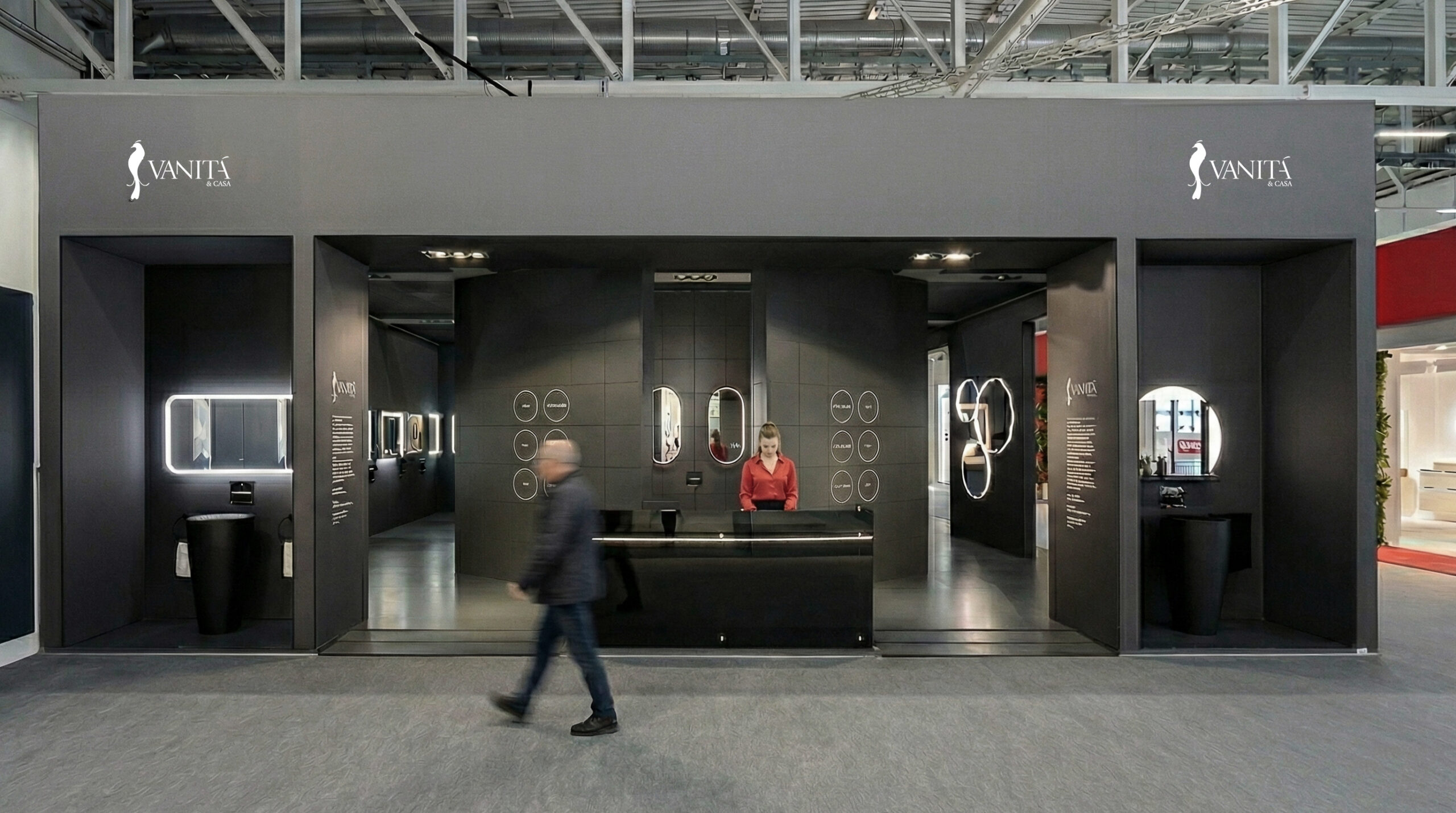 Vista frontale dello stand Vanità & Casa a ISH 2025, con volume monolitico scuro, aperture espositive e prodotti illuminati all’interno.