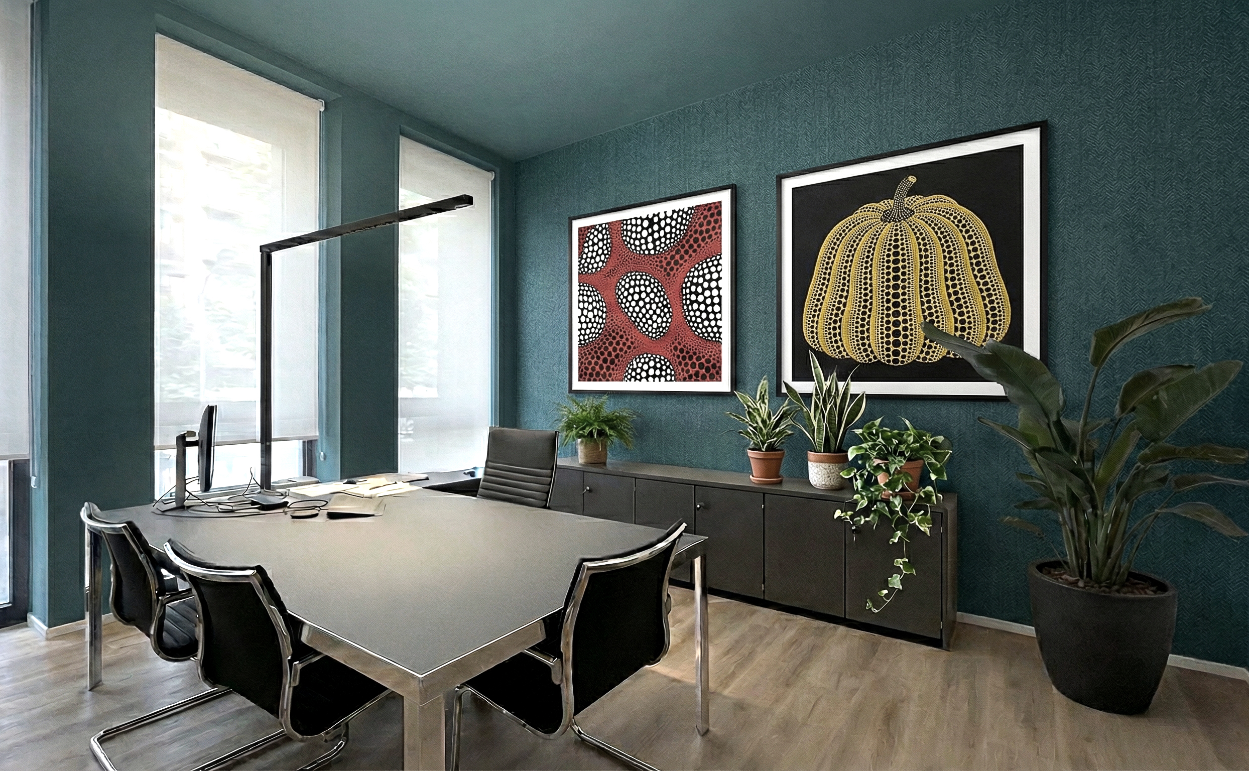 Ufficio del sales director con pareti verde petrolio, opere d’arte alle pareti, arredi neri e numerose piante d’interno.