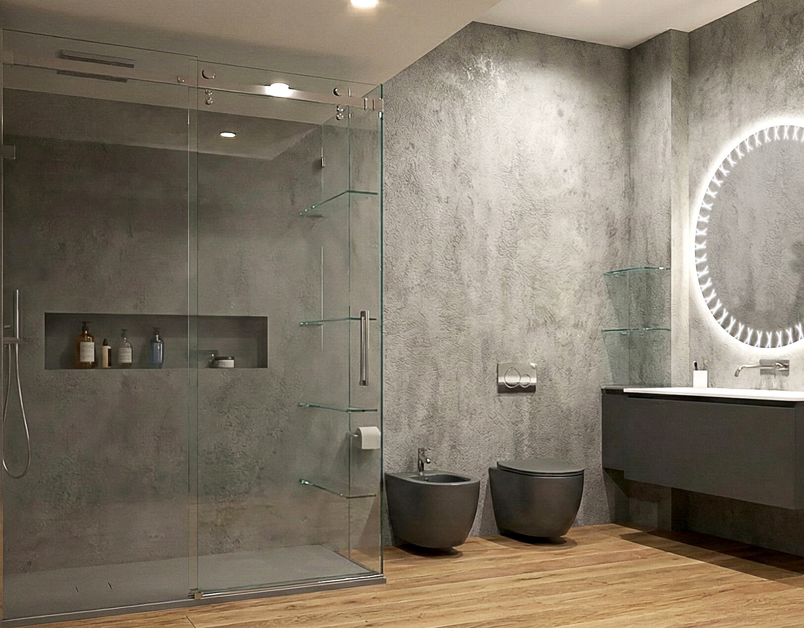 Bagno contemporaneo con doccia walk-in in vetro, rivestimento grigio materico, sanitari sospesi e specchio circolare retroilluminato.
