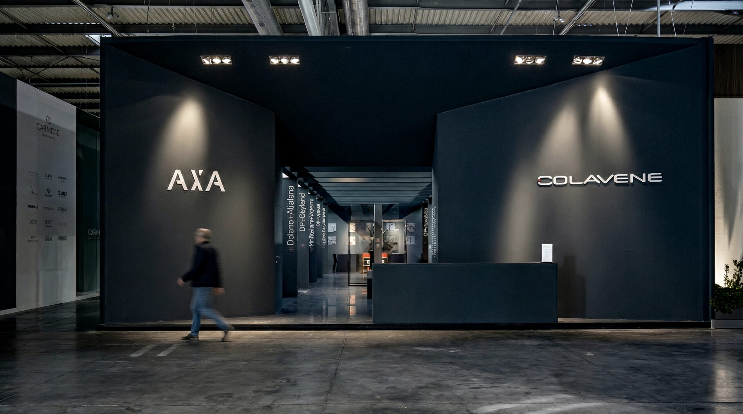 Vista d’insieme dello stand: volumi scuri e segni luminosi guidano la lettura dei brand e delle collezioni.