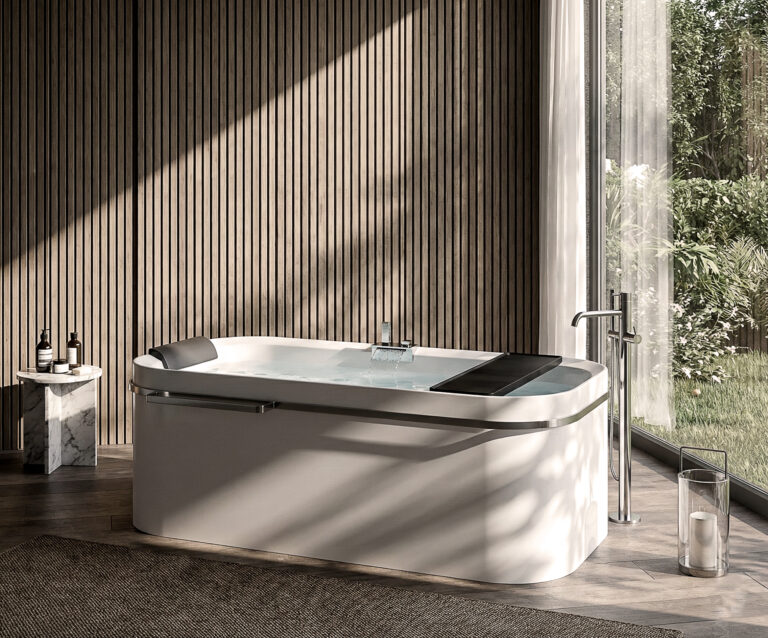 Vasca Divina freestanding con bordo inclinato in bagno con parete a doghe e vista su giardino