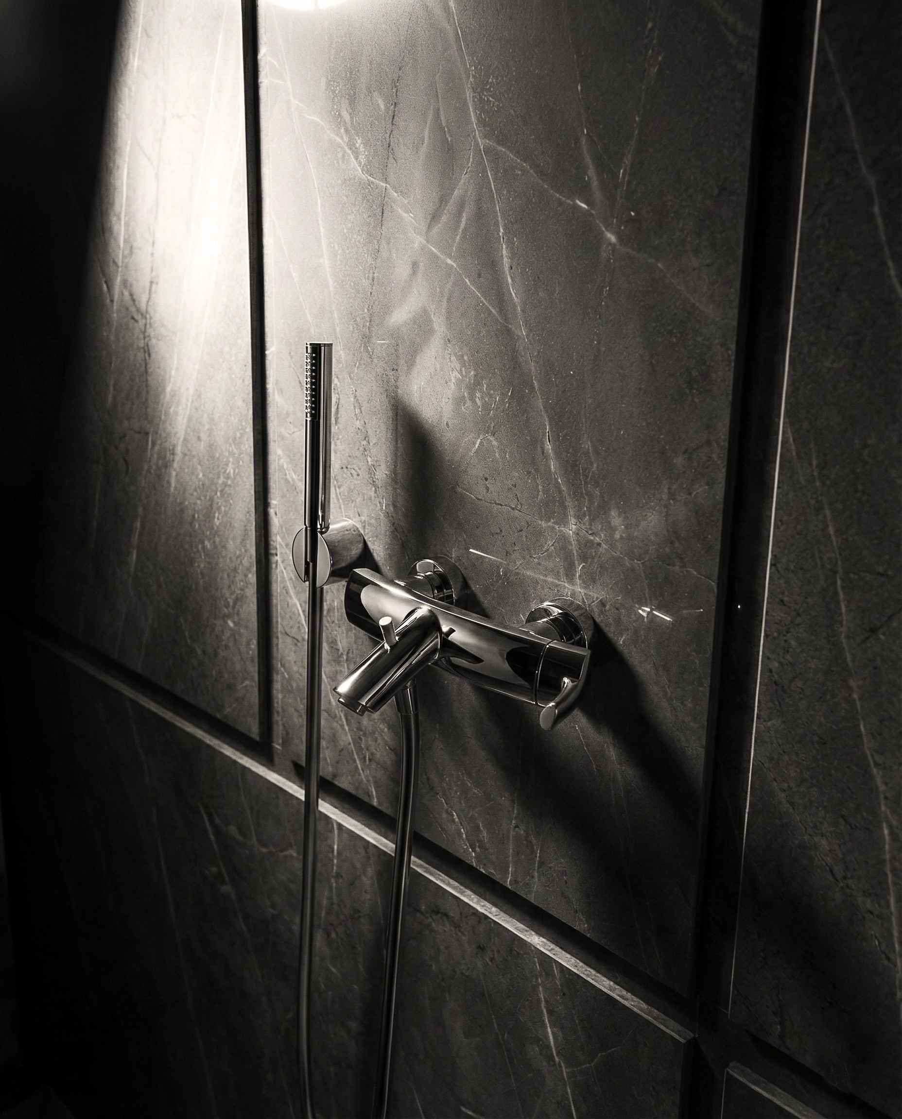 Gruppo vasca/doccia Vizio su rivestimento in pietra scura con doccetta laterale, finitura cromata.