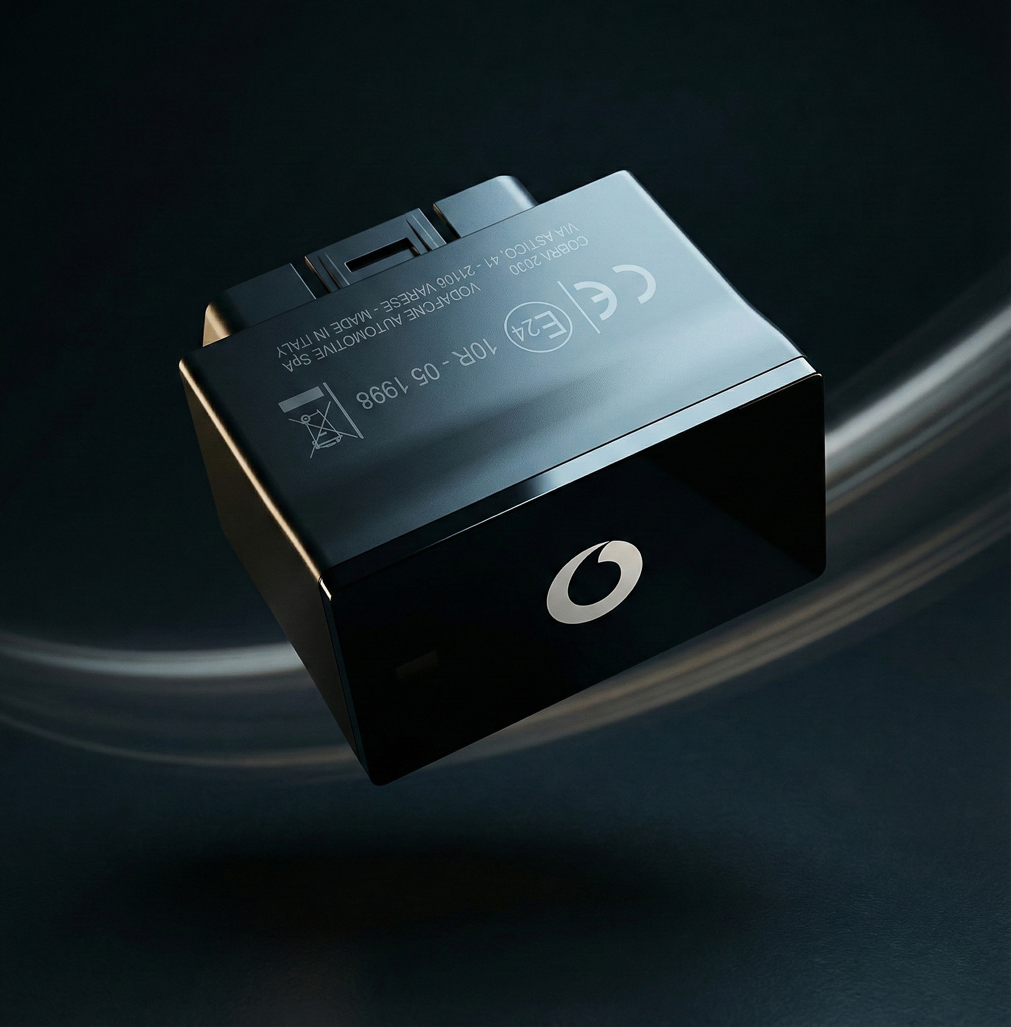 dispositivo IoT nero e rosso per auto, fotografato su fondo scuro.