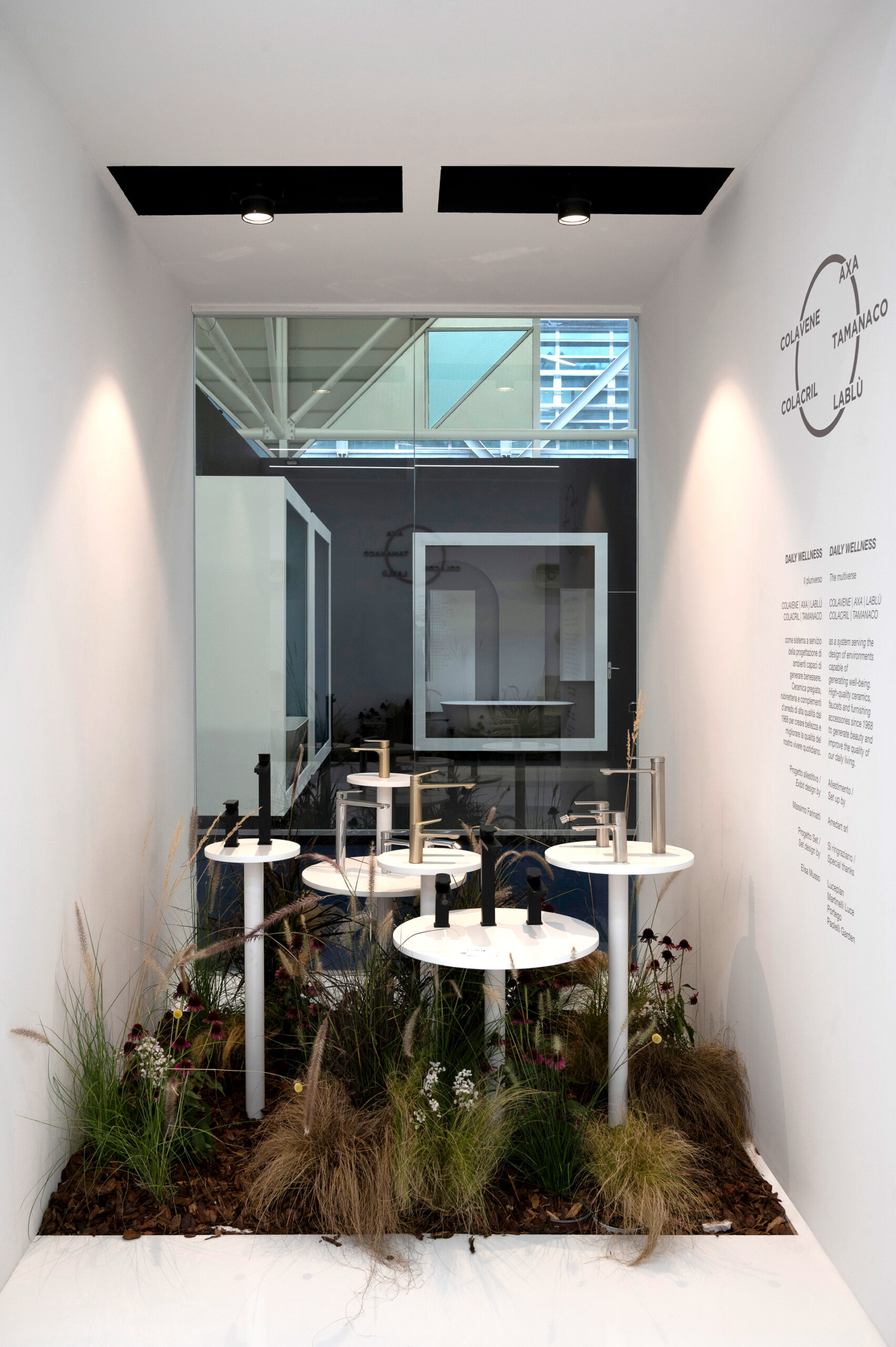 LaBlù a Cersaie 2023: vetrina interna con espositori per rubinetteria che emergono da un piccolo giardino, allestimento white-driven.