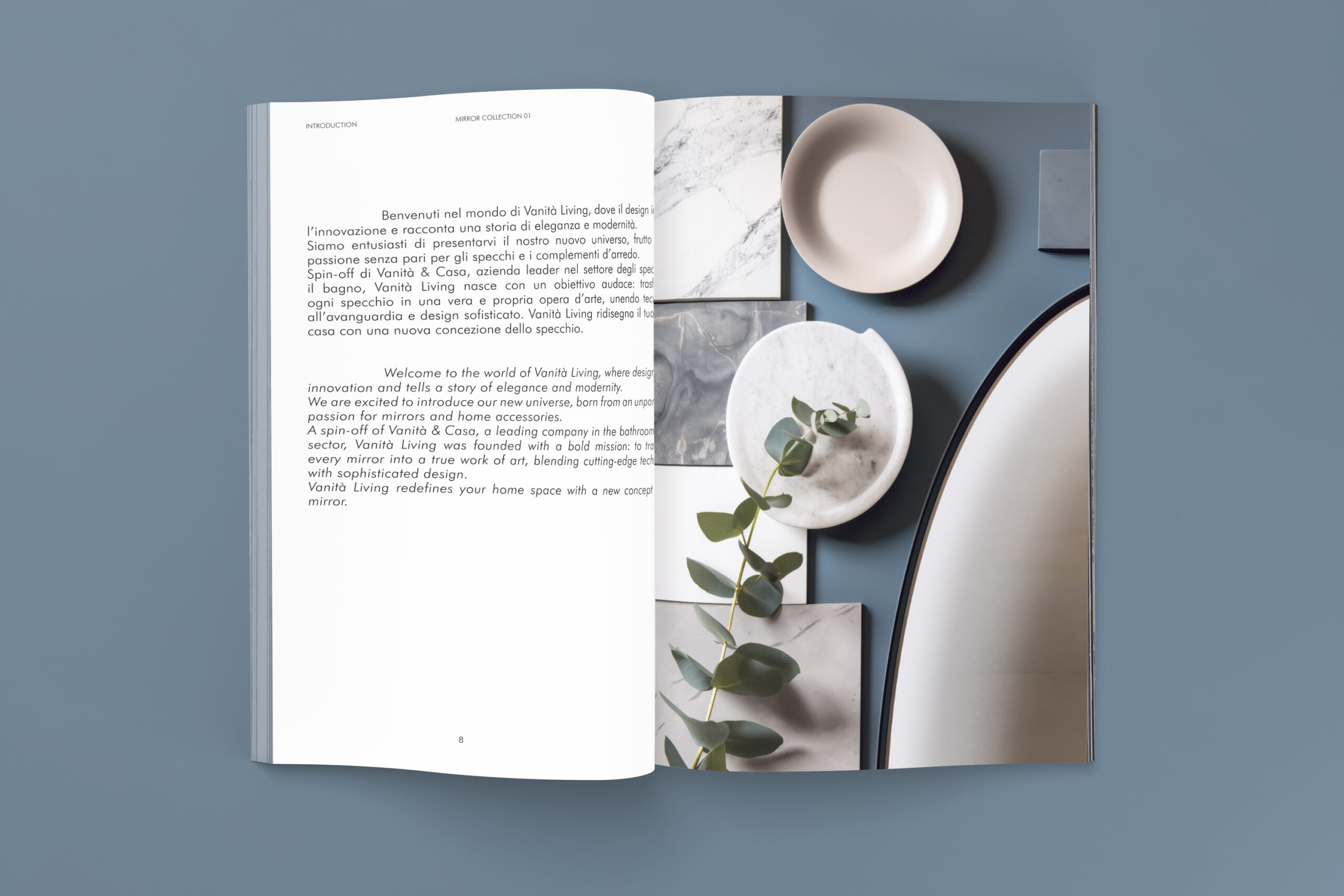Catalogo aperto su sfondo azzurro con testo introduttivo bilingue a sinistra e composizione di superfici chiare, piatti e ramo vegetale a destra.