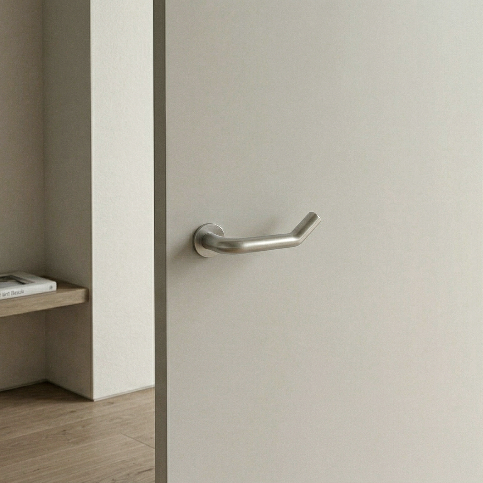 Dettaglio ravvicinato maniglia Elby in acciaio satinato, forma ergonomica con estremità inclinata verso l’alto