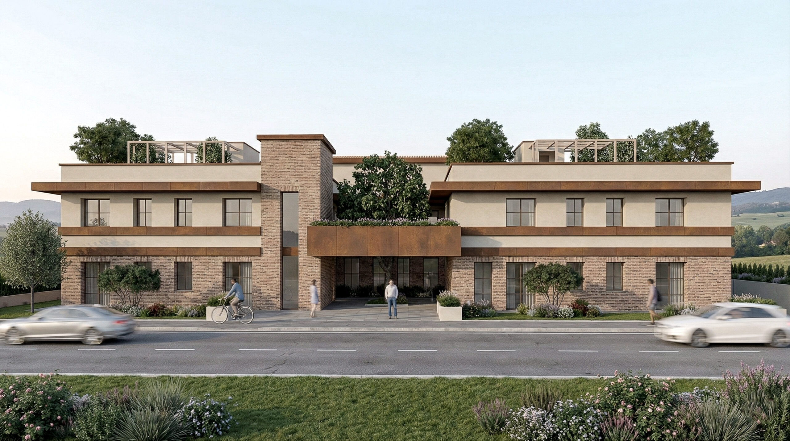 Vista frontale del progetto housing: ingresso centrale tra due volumi simmetrici, verde in primo piano e coperture praticabili; architettura sobria e integrata nel paesaggio.