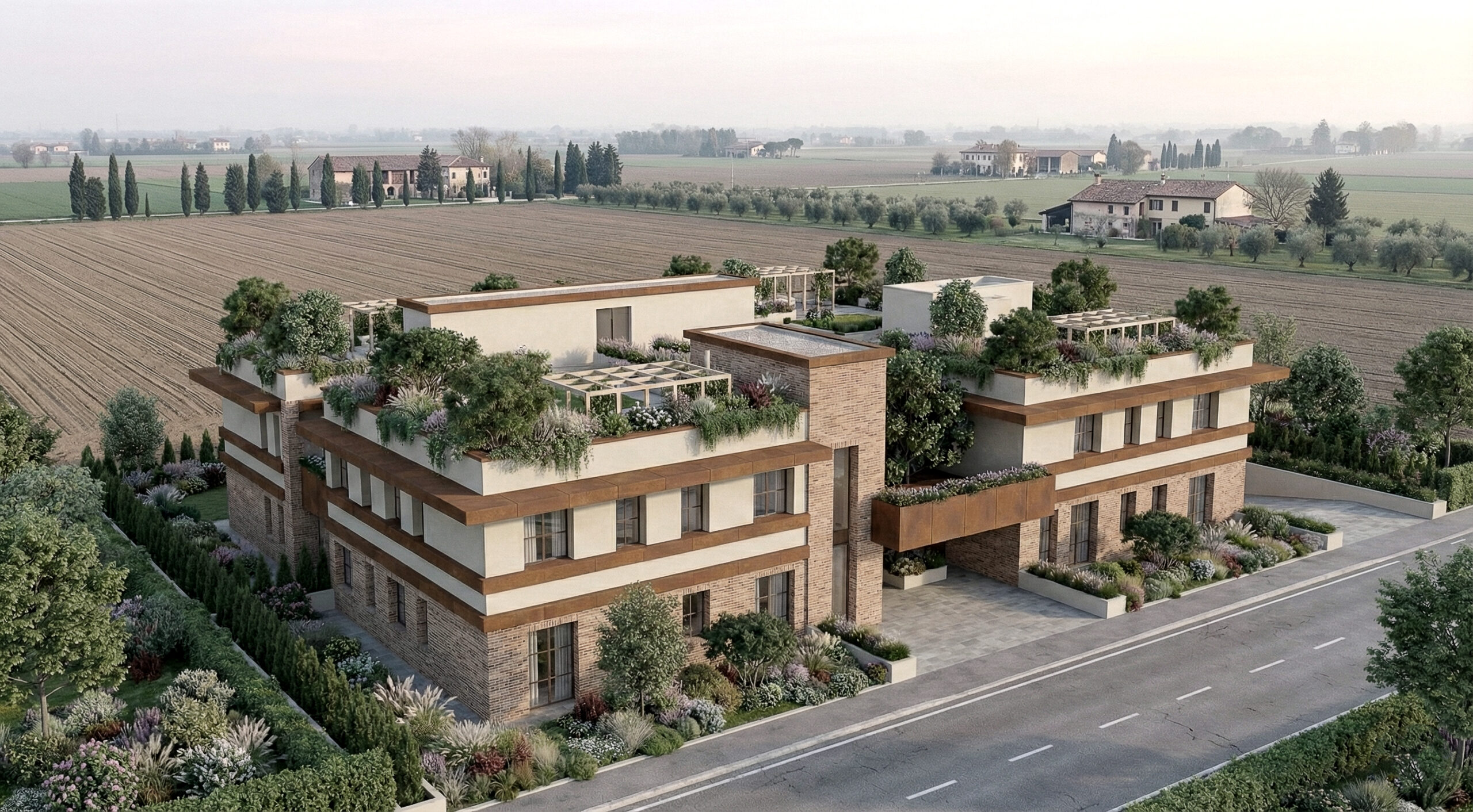 Vista aerea del complesso housing a Verona in contesto rurale: due corpi edilizi, terrazze‑giardino e coperture verdi che estendono l’abitare e migliorano il microclima.